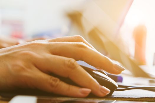 Close-up of female hands using laptop computer, working on laptop with flare light background. Searching Internet ,Businesswoman working at home office
