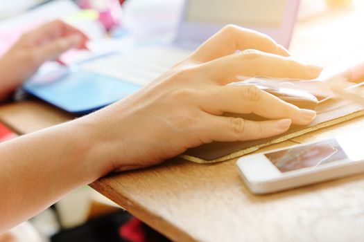 Close-up of female hands using laptop computer, working on laptop with flare light background. Searching Internet ,Businesswoman working at home office