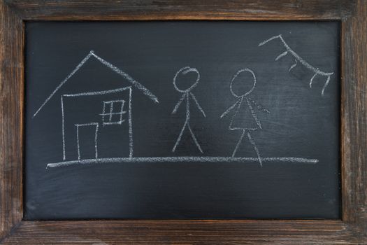 Family, house and sun, painted chalk on a black board