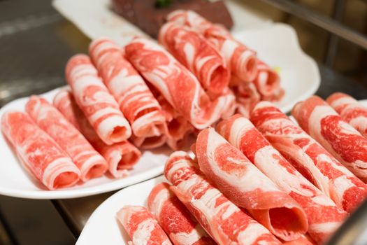 A plate of raw meat in a chinese hot pot restaurant