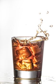 Glass with water and falling crystals of ice