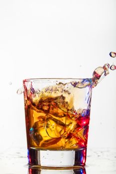 Glass with water and falling crystals of ice