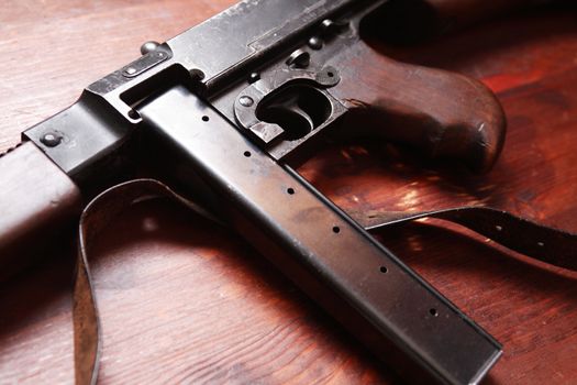 Old USA submachine gun closeup on wooden background
