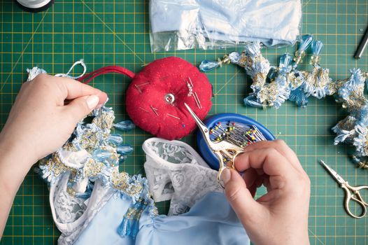 seamstress cuts the thread with sewing scissors