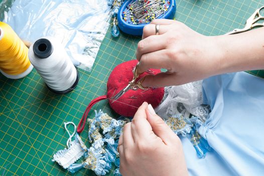 seamstress cuts the thread with sewing scissors