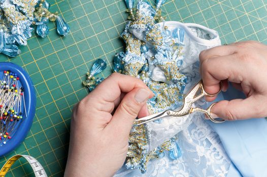 seamstress cuts the thread with sewing scissors