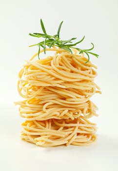 bundles of uncooked spaghetti pasta on white background