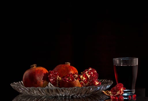 Still life with ripe pomegranates with juice on a close-up table