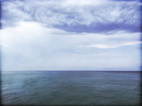 Grungy image of stormy sea and clouds. Gloomy dark sky and water.