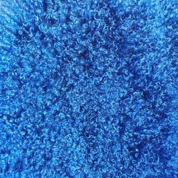 Blue colored sheepskin background. Soft and fluffy natural luxurious material.