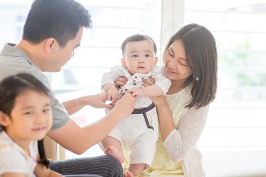 Happy Asian family at home, natural living lifestyle indoors.