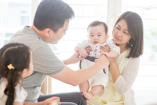 Happy Asian family at home, parents and children, natural living lifestyle indoors.