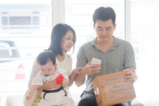 China man scanning QR code with smart phone. Happy Asian family at home, natural living lifestyle indoors.