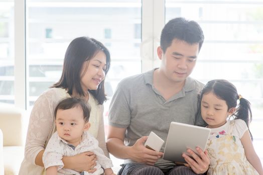 Father using tablet pc and smart phone. Asian family at home, natural living lifestyle indoors.