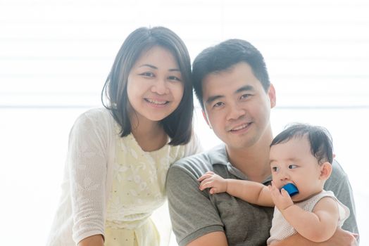 Parents and baby child. Happy Asian family spending quality time at home, natural living lifestyle indoors.