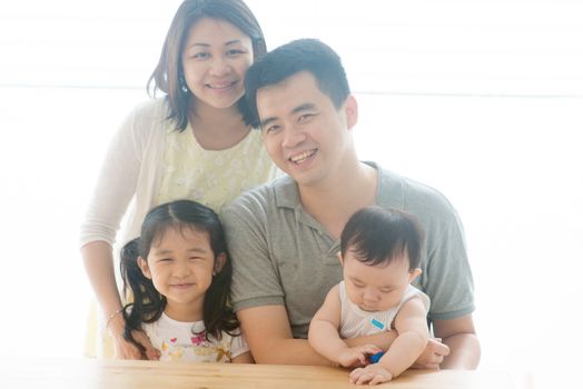 Parents and children portrait. Happy Asian family spending quality time at home, natural living lifestyle indoors.