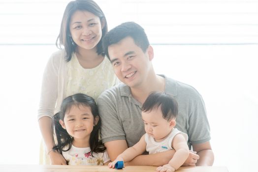 Attractive parents and children. Happy Asian family spending quality time at home, natural living lifestyle indoors.