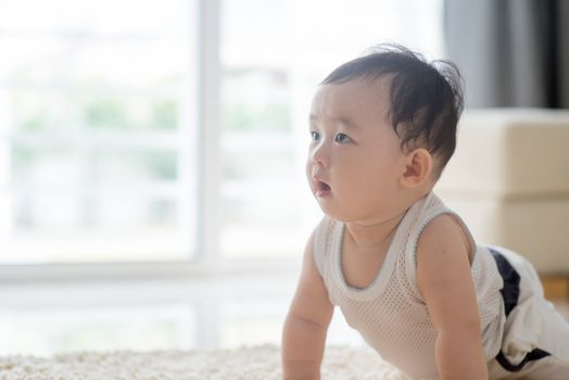 Baby boy crawling on floor. Asian family at home, living lifestyle indoors.