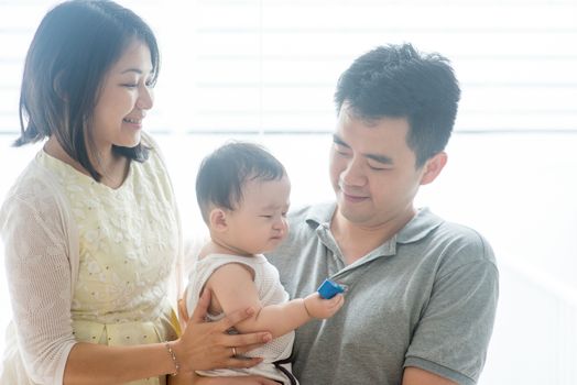 Parents and baby. Happy Asian family spending quality time at home, natural living lifestyle indoors.
