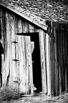 Weathered barn in the Panhandle region of Idaho in black and white with puffy clouds