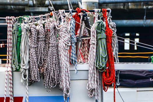 Various sheets and mooring lines on lifeline of sailing yacht.