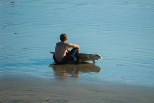 Surfer waits for waves on Pacific Beach