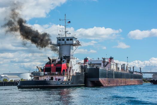 Tug inserted in notch in stern of barge.