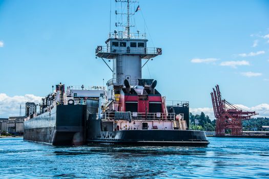 Tug inserted in notch in stern of barge.