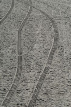 Tire tracks trace the path of a lifeguard in the sand of Huntington Beach
