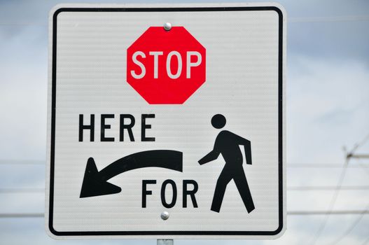 Sign directing motor traffic to stop for pedestrians