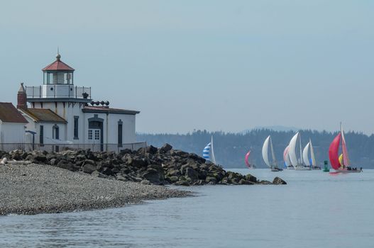 View of Seattle sailboat race with West Point Lighthouse in the foreground.