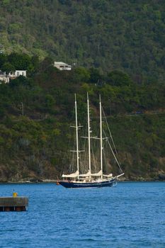 Large, three masted schooner at anchor in British Virgin Islands harbor.