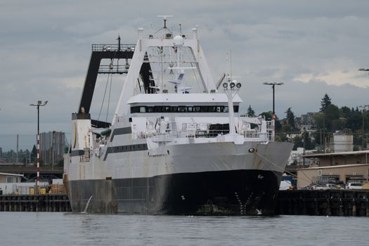 Huge factory trawler tied up to the pier in Seattle on cloudy, flat lit day