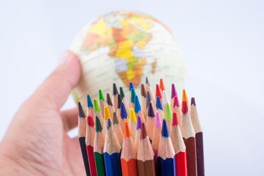 Color pencils of various color and globe on white background