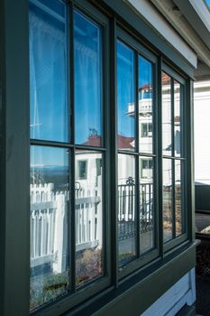 Windows in lighthouse keeper's shed showing clear blue sky and Mukilteo Lighthouse reflected