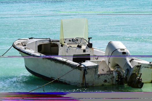 Skiff with outboard tied to palm trees ashore on British Island Beach