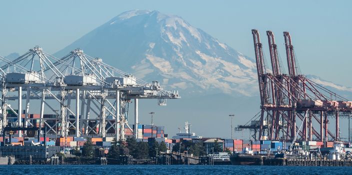 Container Cranes loom over Duwamish Waterway with Mount Rainier in the background.
