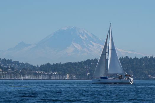 Sailing yacht out for afternoon sail on Puget Sound with Mount Rainier in the background.