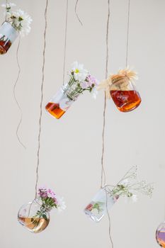 Herbal tea bottles with flowers hanging on strings