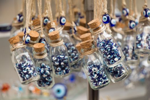 Little transparent glass bottle filled with blue evil eye beads