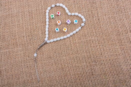 Heart shaped cubes in hand by inside a praying beads