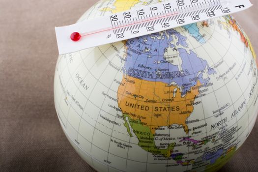 Thermometer placed on a little model globe