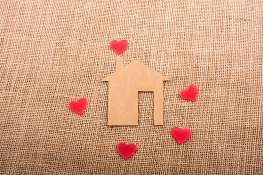 Heart shape around the  paper house with a canvas background
