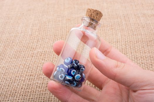 Hand holding Evil eye bead in bottle as  souvenir