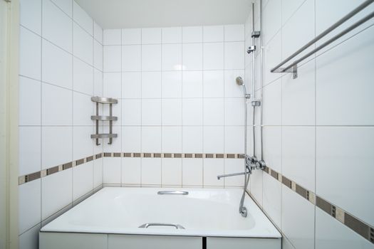 Small beige tile bathroom with bath tube and sink