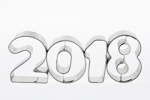 Text two thousand eighteen in metal put figures on a white background as a visualization of the coming new year
