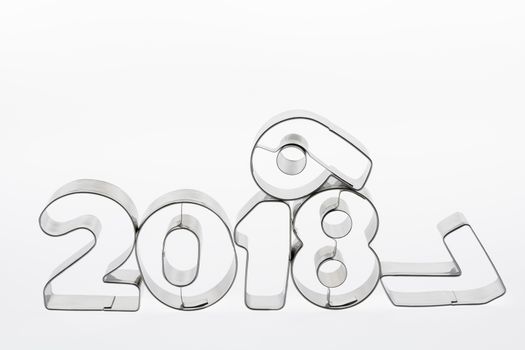 Text two thousand eighteen and nineteen in metal put figures on a white background as a visualization of the coming new year
