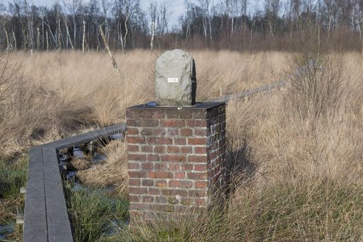 Boundary stone in nature reserve the Wooldse veen on the Southeast side of the municipality of Winterswijk in the Netherlands to the border with Germany. This peat moor area is dissected by the border between the Netherlands and Germany. Therefore there are many boundary stones to be found in this nature reserve.
