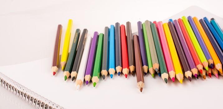 Color pencils placed on a brown notebook