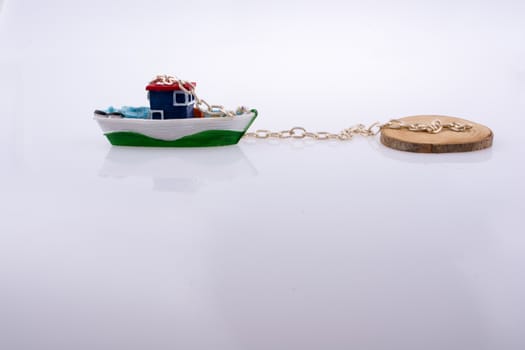 Little colorful model boat with chains on white background